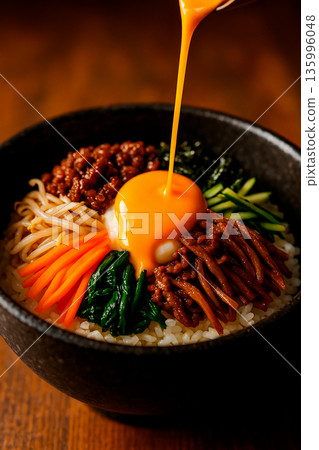 一份熱氣騰騰的石鍋拌飯，裡面有濃鬱的蛋黃。 135996048