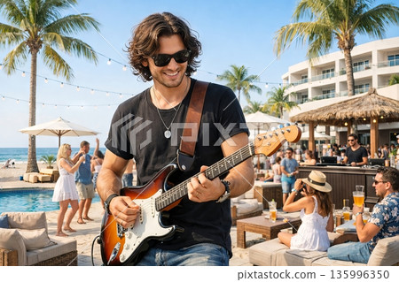Young musician playing electric guitar at beach party. Live music entertainment at coastal resort for summer vacation 135996350
