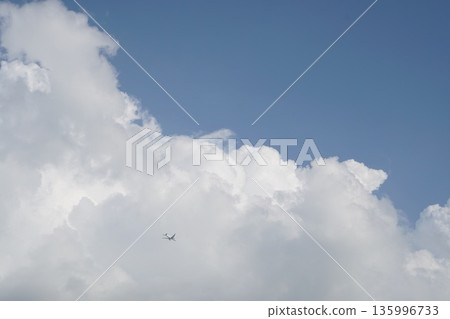 一架飛機飛過夏日湛藍的天空和巨大的積雨雲。 一架飛機飛過夏日湛藍的天空和巨大的積雨雲。 135996733