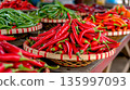 Market display of red and green chili peppers in baskets at local location 135997093