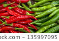Fresh green and red chili peppers on display at a market 135997095