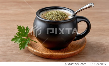 Hot drink served in black cup with herbs on top and green parsley leaf 135997097