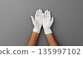 Exhibiting hands adorned with matching latex gloves arranged symmetrically for presentation 135997102