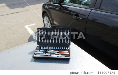 Gray Workbench With Opened Box With Mechanics Tools In Front Of Vehicle 135997525