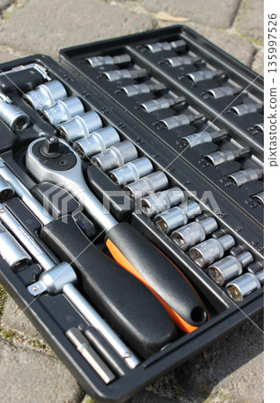 Closeup angle view of repairing tools kit in a plastic box on a concrete surface 135997526