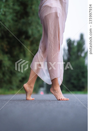 Barefoot Woman Walking on Road Barefoot Woman Walking on Road 135997934