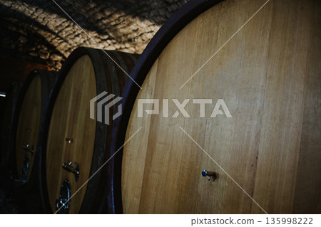 Barrels of wine in a wine cellar. Winery background. Barrels of wine in a wine cellar. Winery background. 135998222