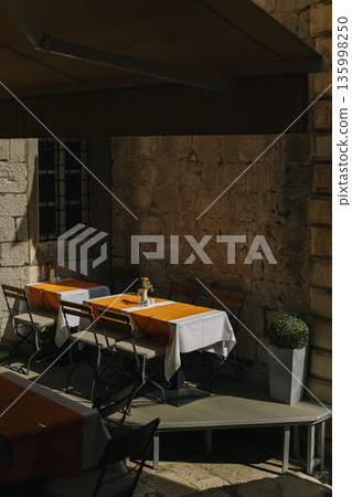 Empty cafe on a street in Dubrovnik old town, Croatia. Travel destination in Croatia. Empty cafe on a street in Dubrovnik old town, Croatia. Travel destination in Croatia. 135998250