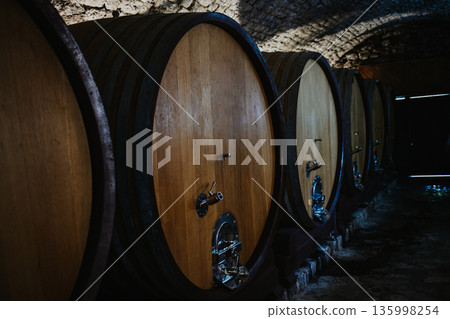 Barrels of wine in a wine cellar. Winery background. Barrels of wine in a wine cellar. Winery background. 135998254