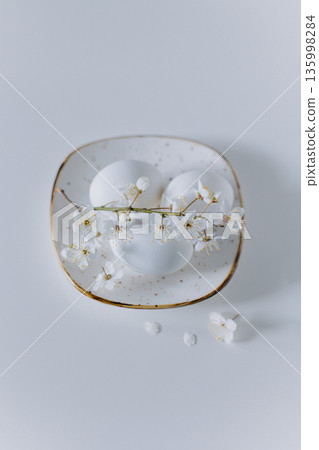 Beautiful branch with white blossom and eggs on a white background. Minimal concept. Beautiful branch with white blossom and eggs on a white background. Minimal concept. 135998284