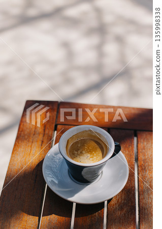 Cup of black coffee on a table in a street cafe. Cup of black coffee on a table in a street cafe. 135998338
