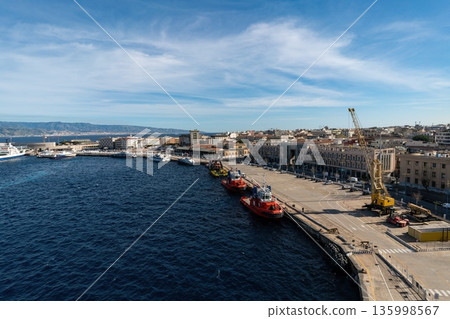 Messina harbor with red tugboats, industrial quay and yellow crane. Sicily, Italy Messina harbor with red tugboats, industrial quay and yellow crane. Sicily, Italy 135998567