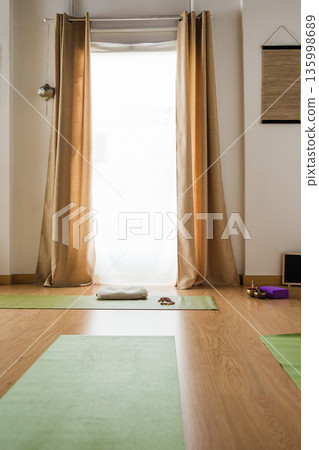 Empty yoga studio interior with mats and natural light Empty yoga studio interior with mats and natural light 135998689