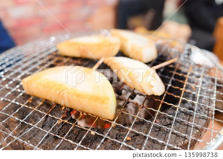 Close-up of onions being cooked on a charcoal grill Close-up of onions being cooked on a charcoal grill 135998738