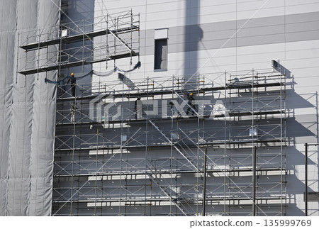 在新建物流設施施工現場,使用起重機拆除鷹架 在新建物流設施施工現場,使用起重機拆除鷹架 135999769