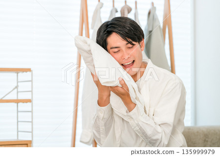 一位男士對洗過的浴巾的手感很滿意。 135999979