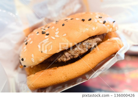 A single hamburger and a plate of fast food A single hamburger and a plate of fast food 136000426