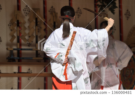 Kagura offering: A shrine maiden performs a sword dance Kagura offering: A shrine maiden performs a sword dance 136000481