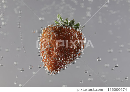 特寫鏡頭：草莓漂浮在水中，周圍環繞著氣泡。 136000674