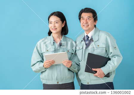 Middle-aged engineer wearing blue work clothes Middle-aged engineer wearing blue work clothes 136001002