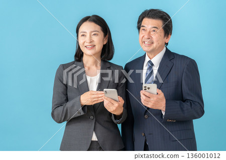藍色背景上的中年男女商務人士 136001012