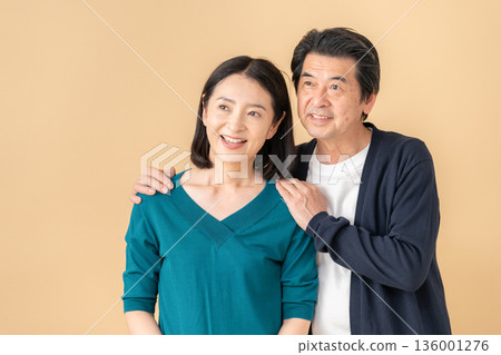 一對中年夫婦在米色背景前約會 136001276