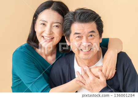 一對中年夫婦在米色背景前約會 136001284