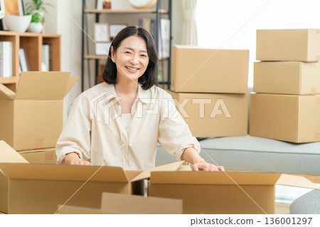 Middle-aged woman moving house Middle-aged woman moving house 136001297