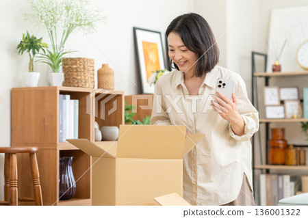 Middle-aged woman moving house 136001322