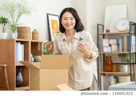 Middle-aged woman moving house Middle-aged woman moving house 136001323