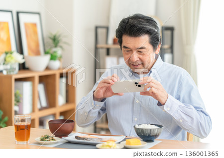 Middle-aged man eating at home Middle-aged man eating at home 136001365