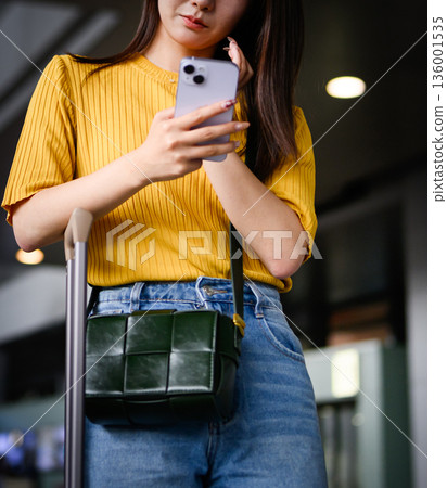 一名女子在機場查看她的智慧型手機。照片由關西國際機場（KIX）提供。 136001535
