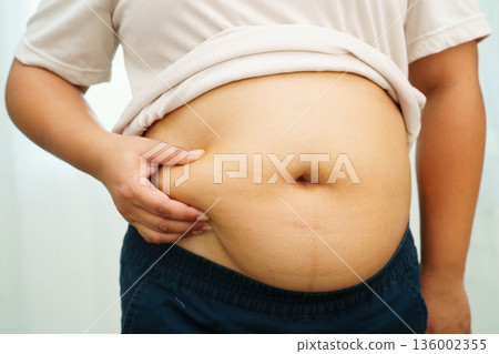 Asian woman use hand to squeeze fat belly big size overweight and obesity. Asian woman use hand to squeeze fat belly big size overweight and obesity. 136002355