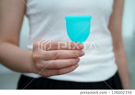 Asian woman holding menstrual cup for hygiene menstrual period cycle protection. 136002356