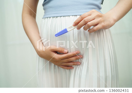 Asian holding pregnancy test for female of ovulation day, fetus, maternity, childbirth, birth control. Asian holding pregnancy test for female of ovulation day, fetus, maternity, childbirth, birth control. 136002431