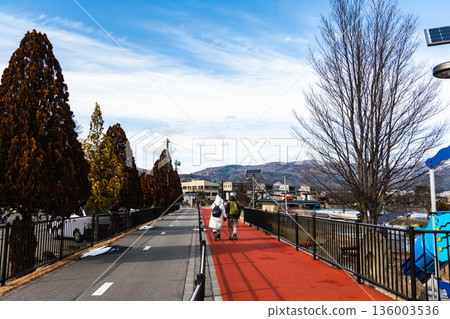 A couple walking along the promenade along Lake Suwa in winter A couple walking along the promenade along Lake Suwa in winter 136003536
