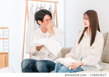 A couple folding laundry in the living room (damp, damp smell, drying indoors) A couple folding laundry in the living room (damp, damp smell, drying indoors) 136003627
