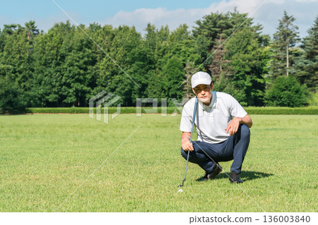 男高爾夫球手在高爾夫球場綠地上閱讀台詞 136003840
