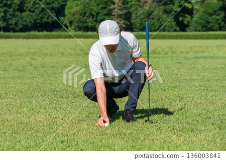 男高爾夫球手在高爾夫球場綠地上閱讀台詞 136003841