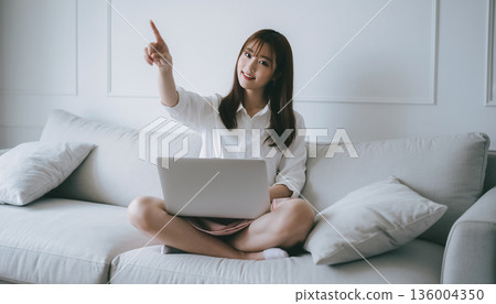 A smiling Japanese woman filing her tax return using her smartphone at home. Pointing pose and household management image A smiling Japanese woman filing her tax return using her smartphone at home. Pointing pose and household management image 136004350