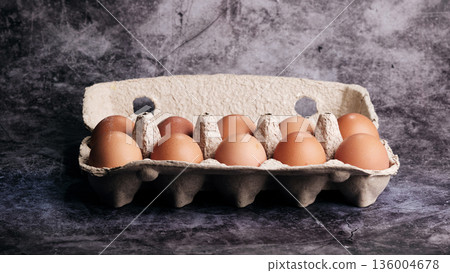 Ten brown chicken eggs are presented in an open, eco-friendly cardboard carton Ten brown chicken eggs are presented in an open, eco-friendly cardboard carton 136004678