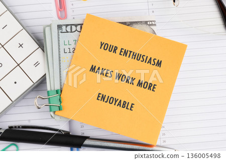 Yellow sticky note with enthusiasm improves work clipped to a stack of bills, calculator, and pen on a desk 136005498