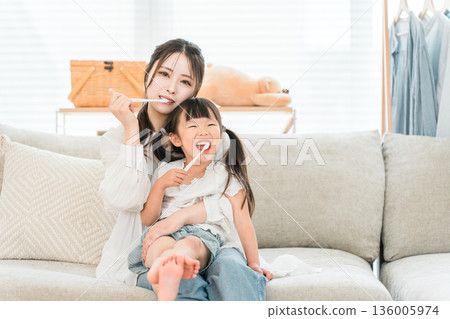 Parents and children brushing their teeth with their daughter in the living room, mother and child, family, mother 136005974