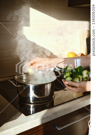 Preparing smashed broccoli with cheese in kitchen during daytime 136006204