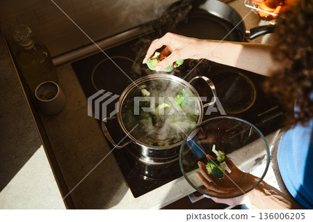 Preparation of smashed broccoli with cheese in a kitchen on a sunny afternoon 136006205