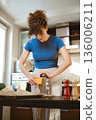 Woman grates cheese in a bright kitchen 136006211