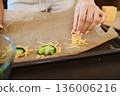 Preparation of smashed broccoli with cheese on a baking sheet in the kitchen 136006216