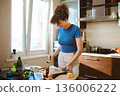 Woman shifting smashed broccoli with cheese from baking sheet on a plate 136006222