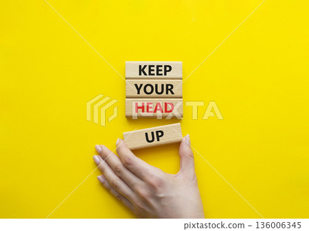 Keep Your Head Up symbol. Concept words Keep Your Head Up on wooden blocks. Beautiful bright yellow background. Businessman hand. Business and Keep Your Head Up concept. Copy space. Keep Your Head Up symbol. Concept words Keep Your Head Up on wooden blocks. Beautiful bright yellow background. Businessman hand. Business and Keep Your Head Up concept. Copy space. 136006345