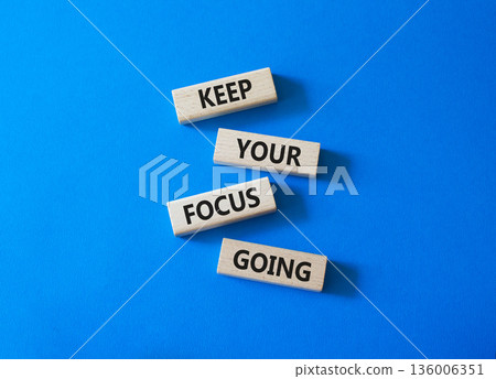 Focus symbol. Concept words Keep Your Focus Going on wooden blocks. Beautiful bright blue background. Business and Keep Your Focus Going concept. Copy space. 136006351